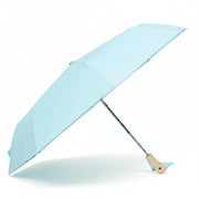 Popsicle blue compact duck umbrella open resting on light background