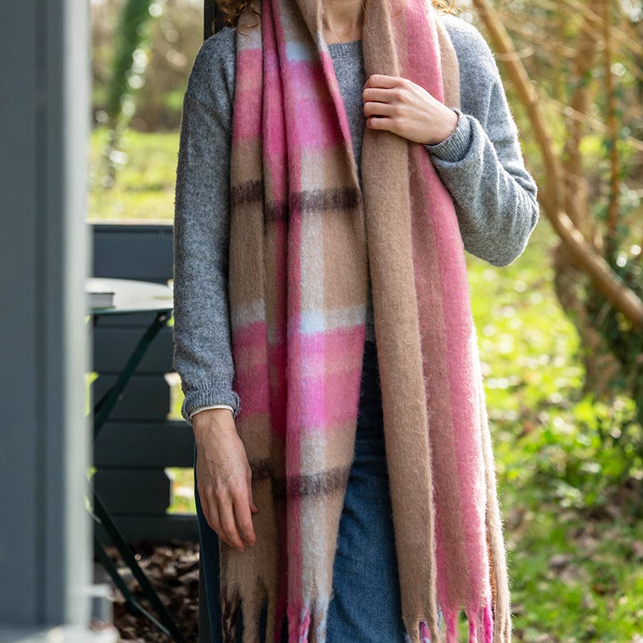 Taupe and pink check scarf worn loose over a grey jumper outdoors
