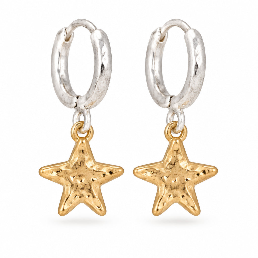 Silver hoop earrings with hammered gold star charms on a white surface