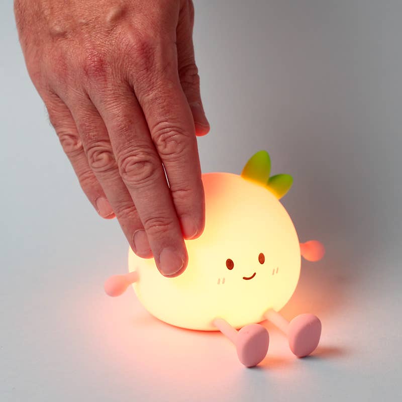 Hand tapping Peach LED Night Light to adjust brightness.