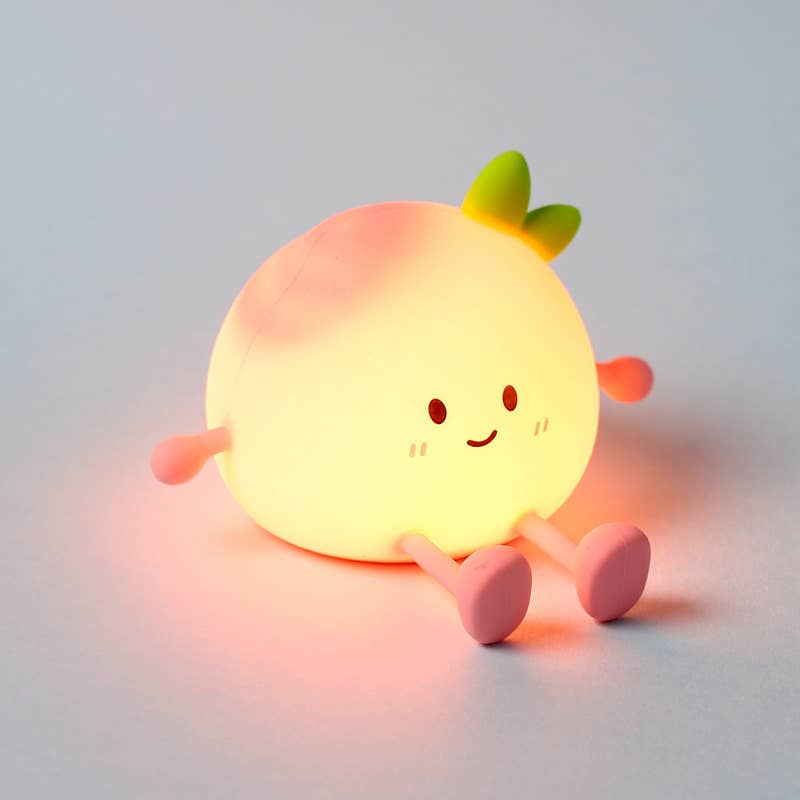 Peach LED Night Light glowing softly with smiling face and green leaf detail.