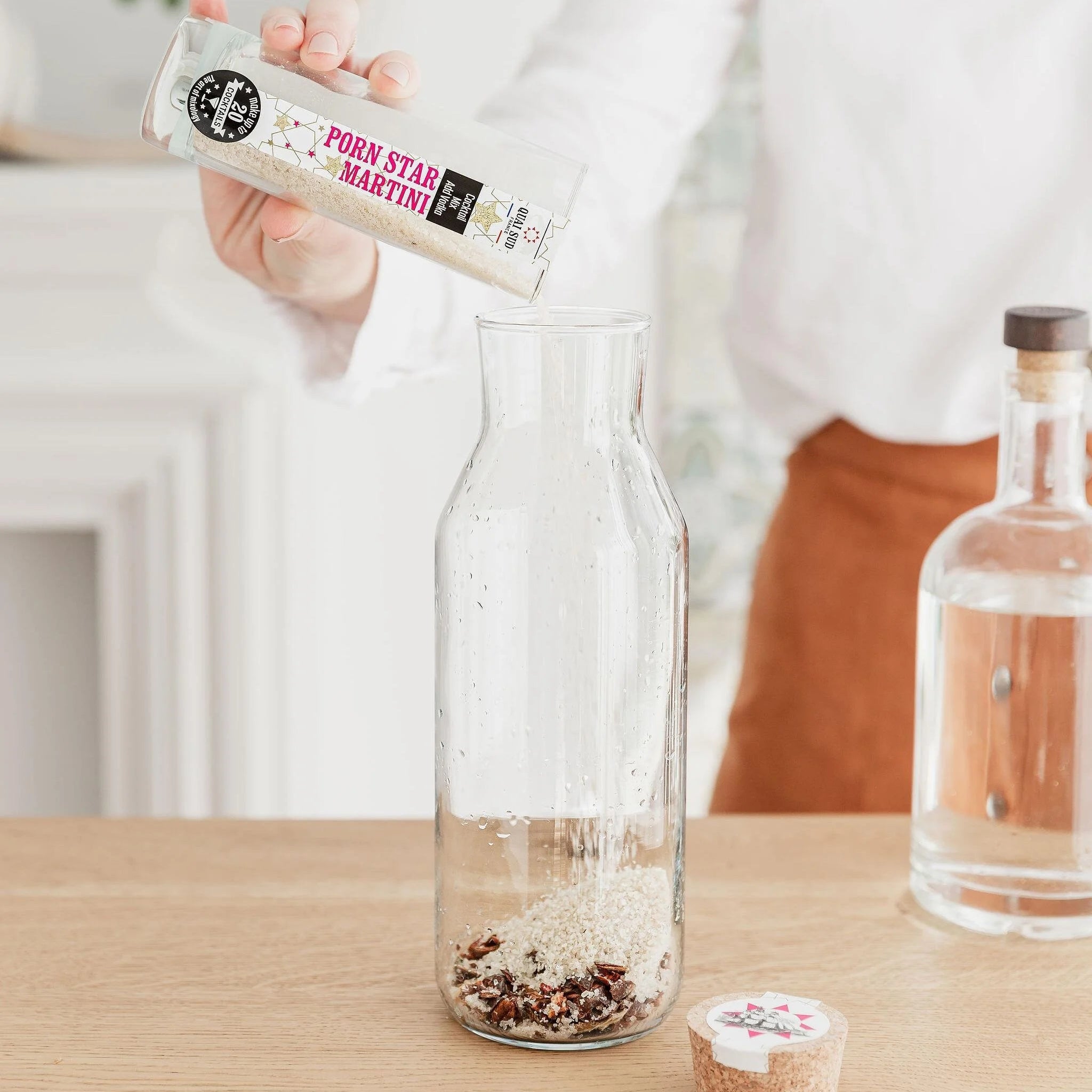 Pouring Porn Star Martini Mix into glass jug for infusion.