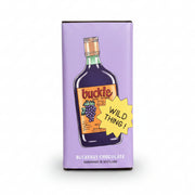 Buckfast chocolate bar in lilac buckie bottle wrapper held against pink graffiti