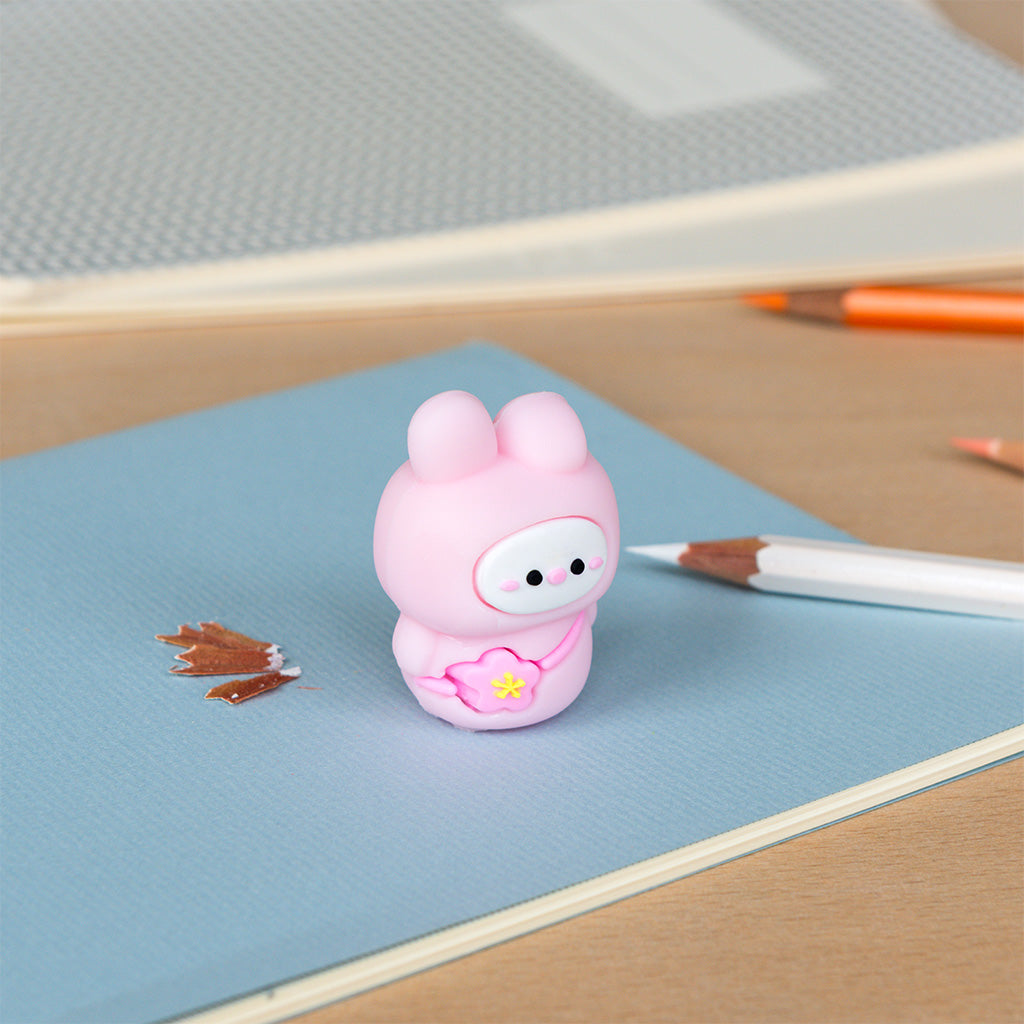 Pink bunny pencil sharpener on a desk with a paintbrush