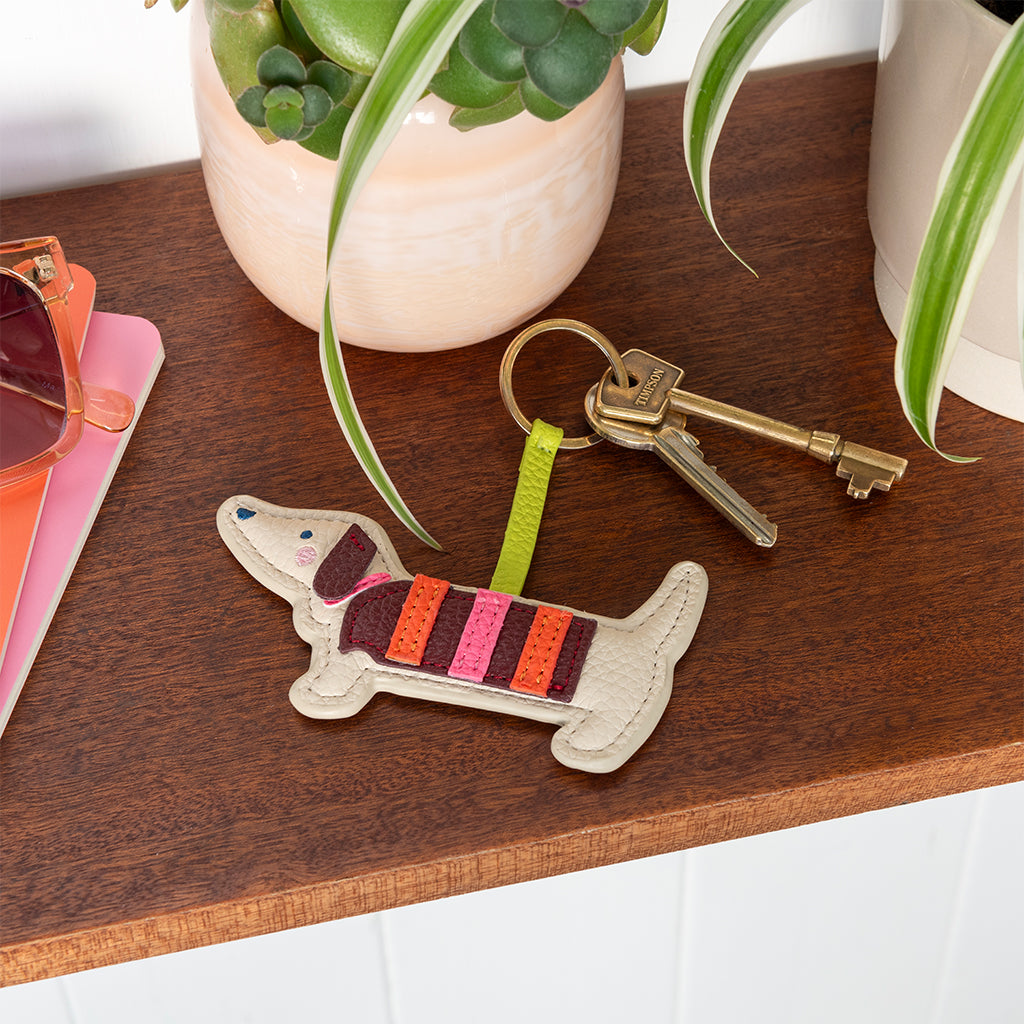 Sausage dog keyring attached to a set of keys on a dark wooden table