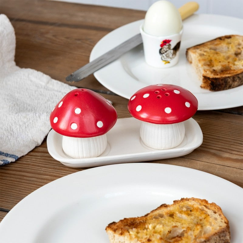 Mushroom salt and pepper shakers on a breakfast table with boiled egg and toast