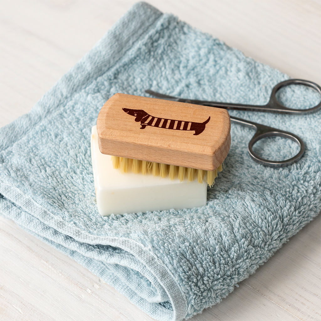 Wooden nail brush photographed beside a basin with soap