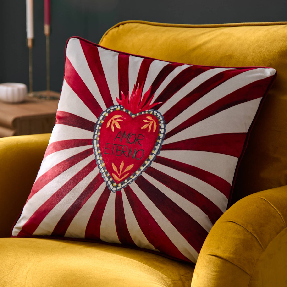 Amor Eterno cushion on a mustard velvet armchair