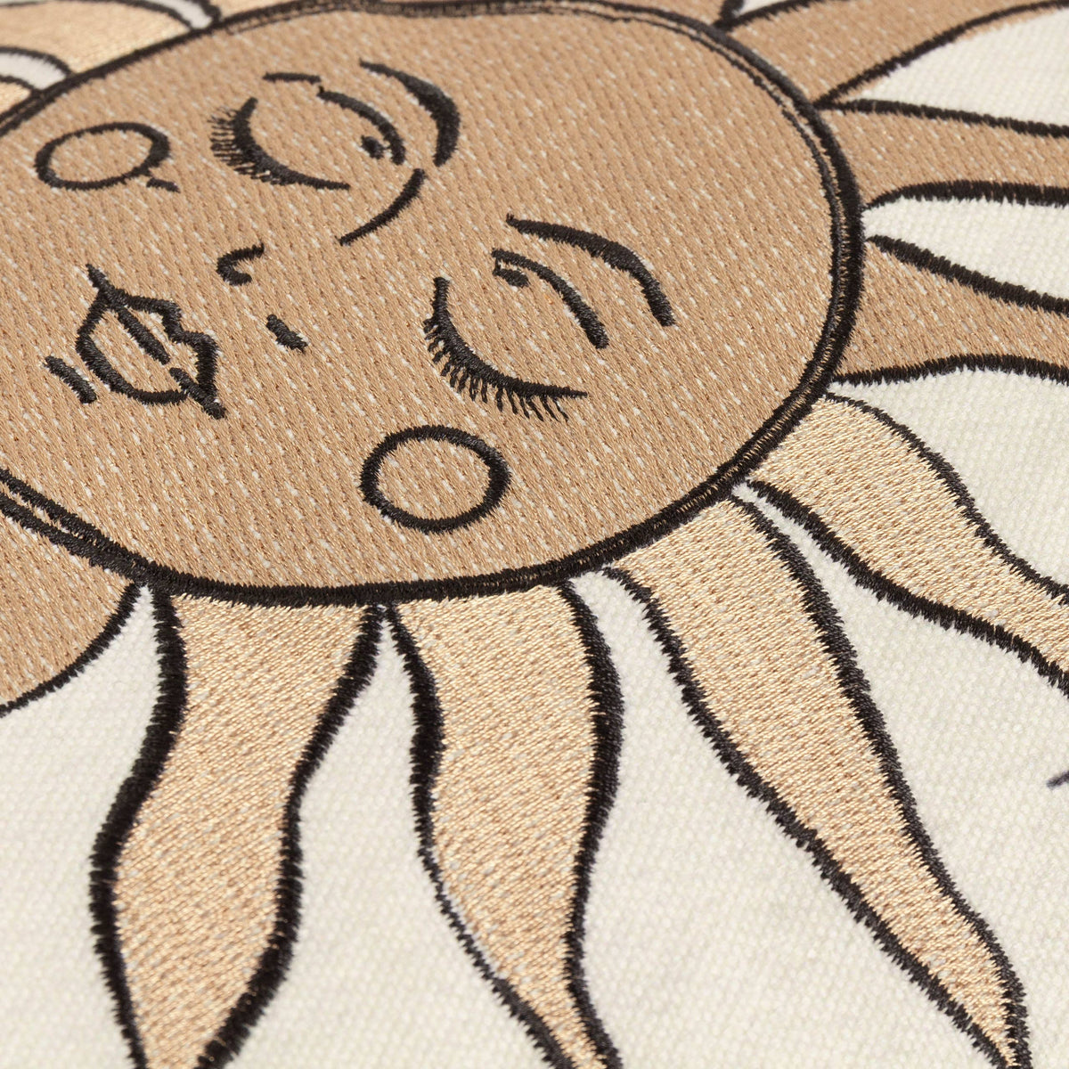 Close up of the embroidered sleeping sun face