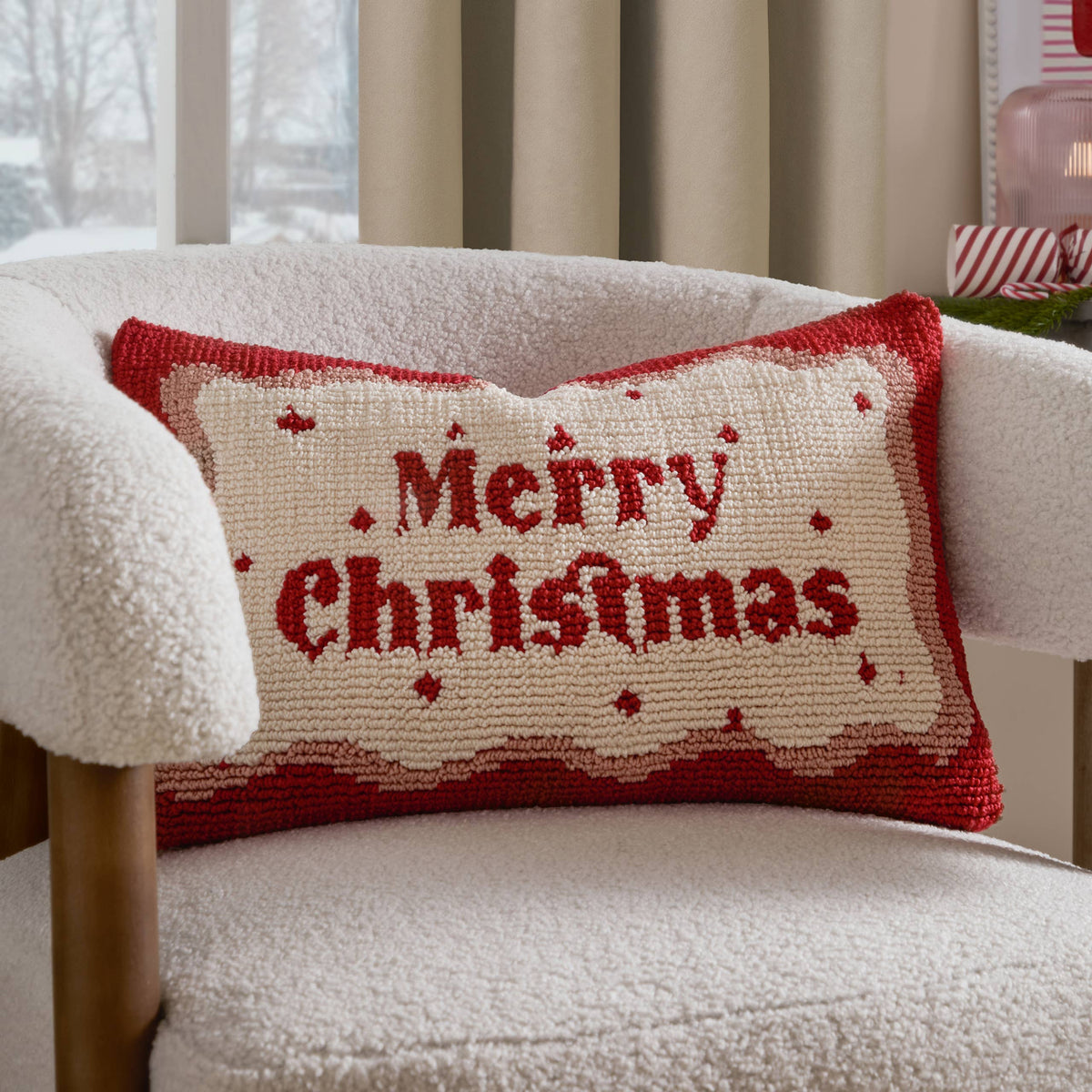 Merry Christmas cushion on a cream boucle chair in a festive room