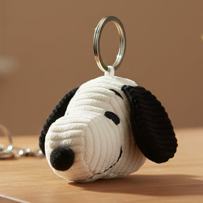 Snoopy head corduroy keyring on wooden surface beige background