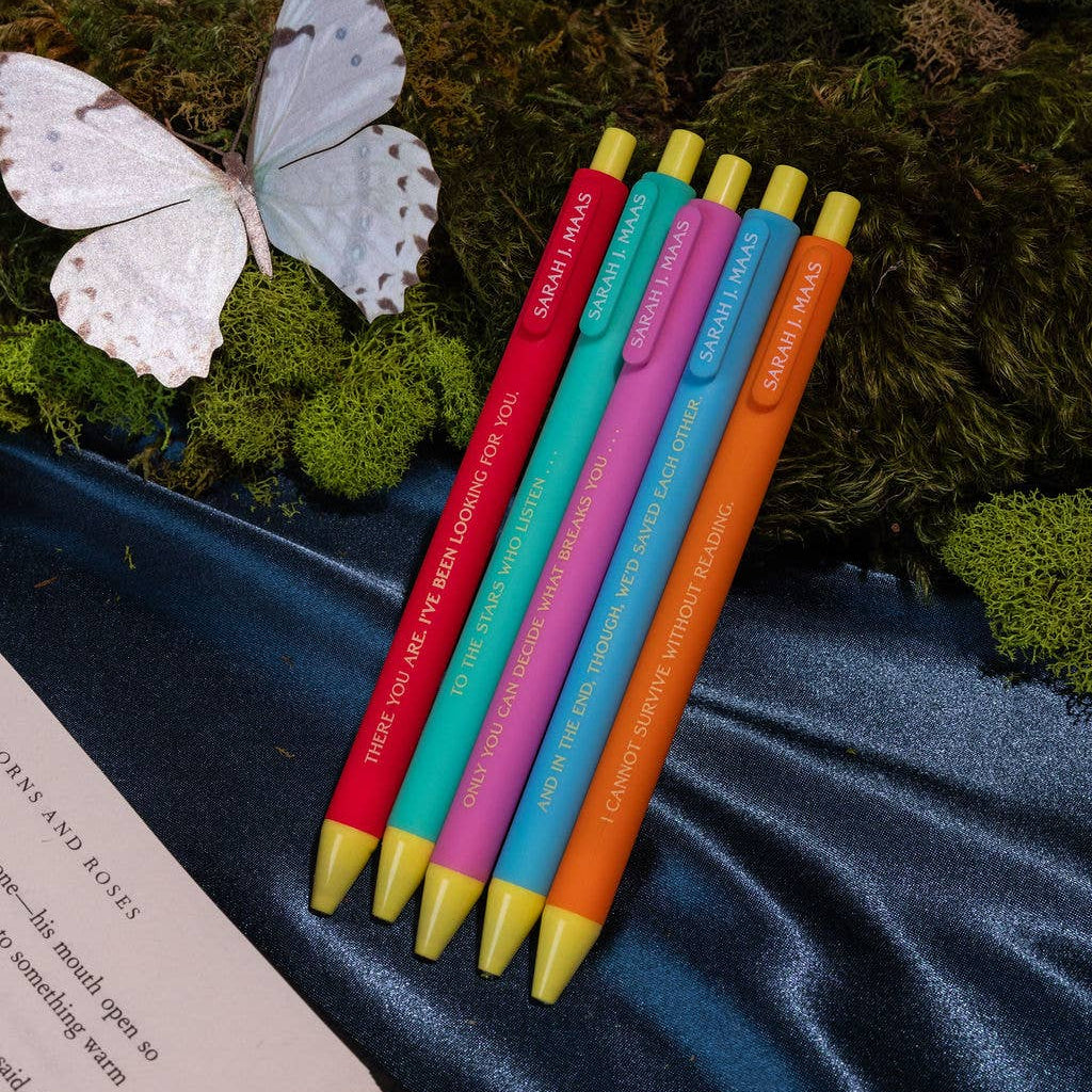 A Court of Thorns and Roses Click Pen Set on velvet with moss and a butterfly