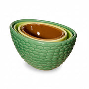 Avocado measuring cups nested together showing green textured exterior on white background
