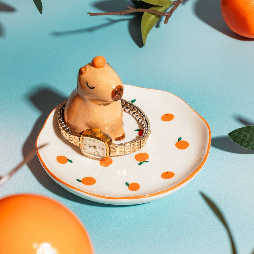 Capybara trinket dish with gold watch on turquoise background lifestyle shot