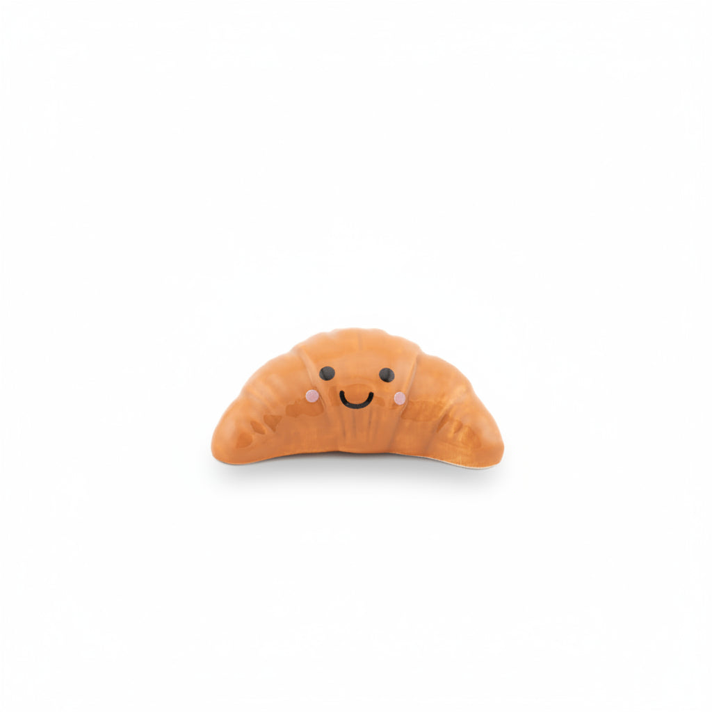 Single croissant token with smiley face on white background front view
