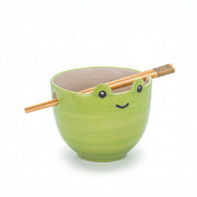 Green ceramic frog noodle bowl with bamboo chopsticks on white background