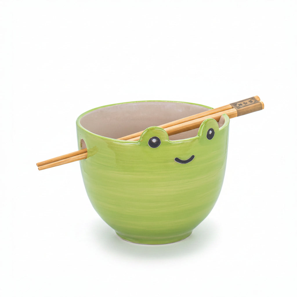 Green ceramic frog noodle bowl with bamboo chopsticks on white background