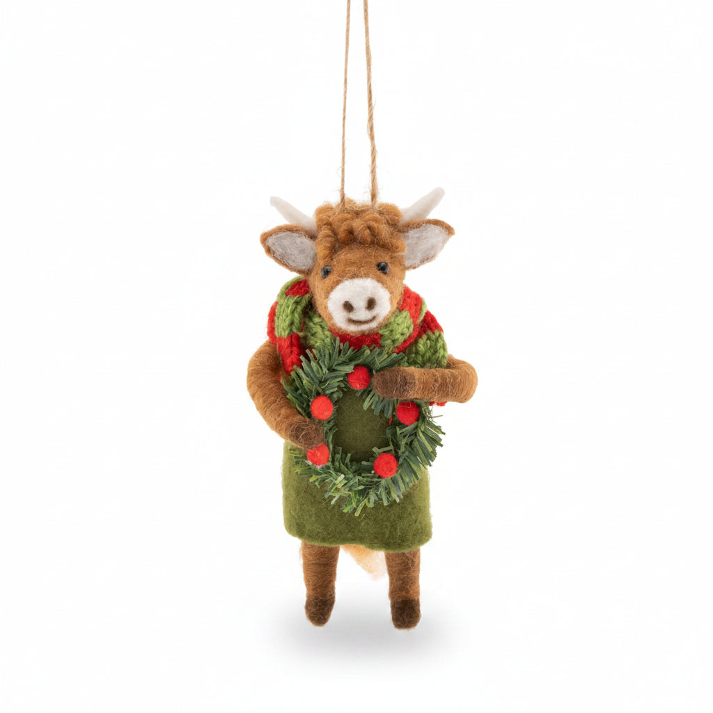 Felt Highland cow decoration in a green coat holding a berry wreath