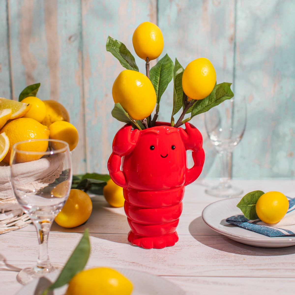 Lobster vase filled with lemons and foliage on a styled summer table