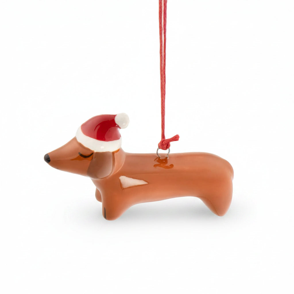 Ceramic sausage dog decoration in a red Santa hat on red cord