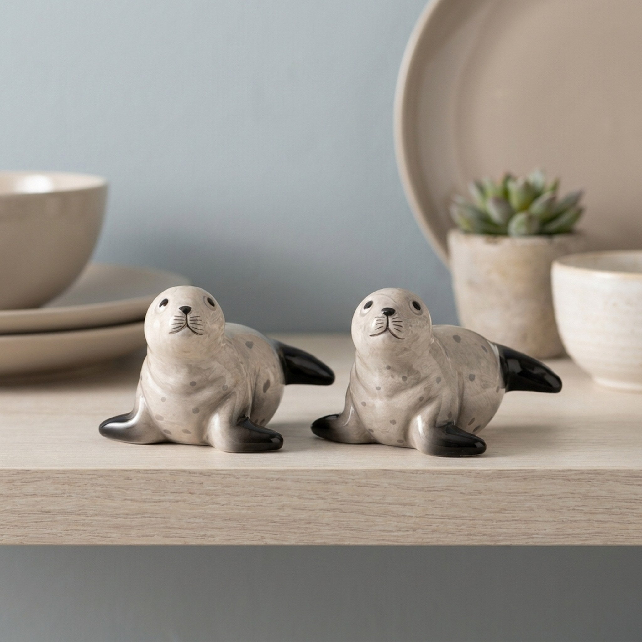 Seal Salt and Pepper Shakers on a pale wooden kitchen shelf