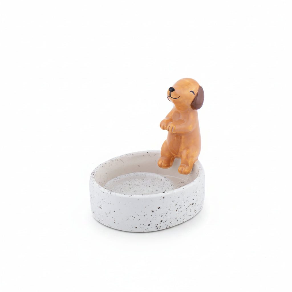 Dog figurine on a small round speckled dish with a white background