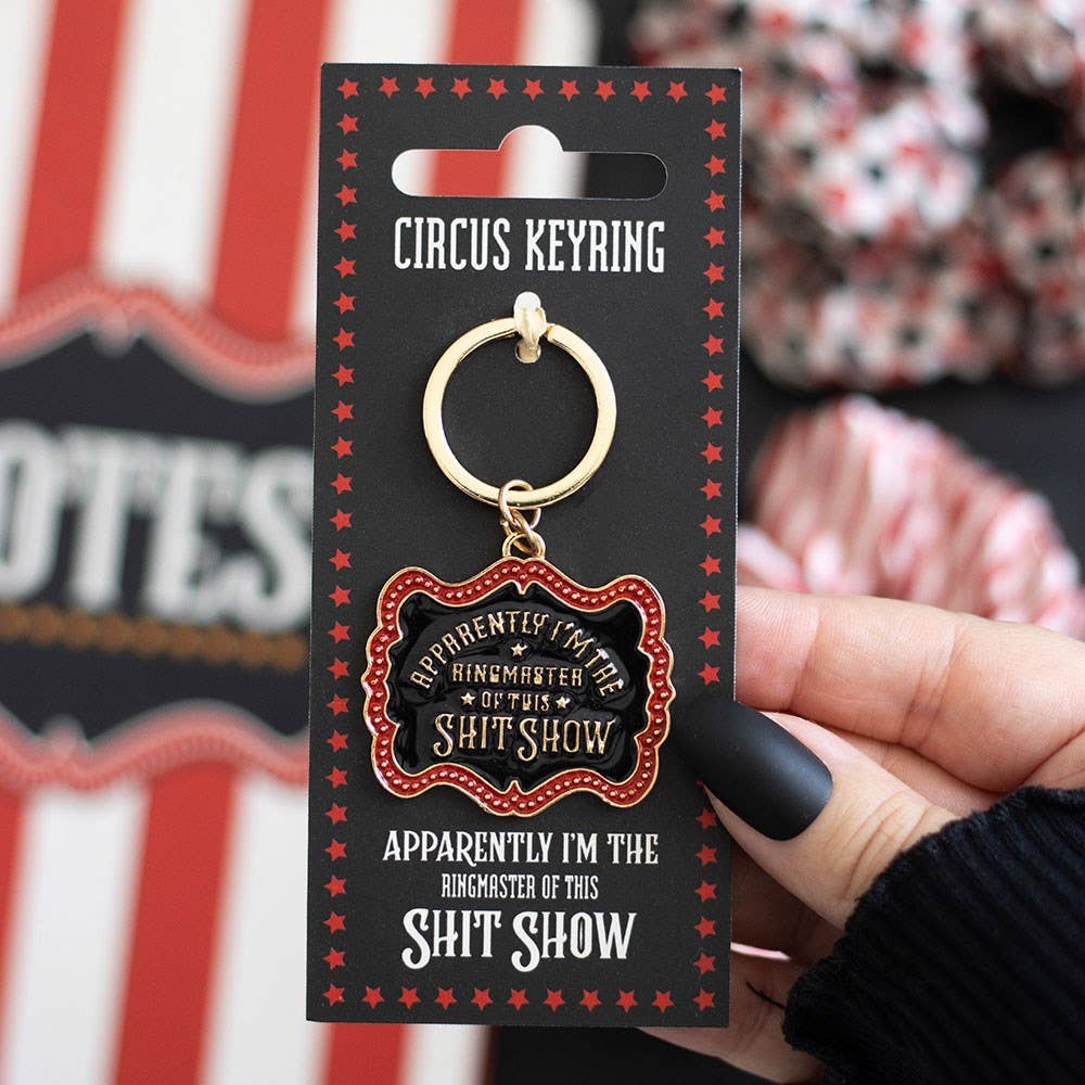 Enamel keyring on red packaging card with circus-themed background