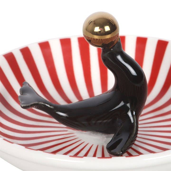 Angled view of ceramic dish showing circus design on white background
