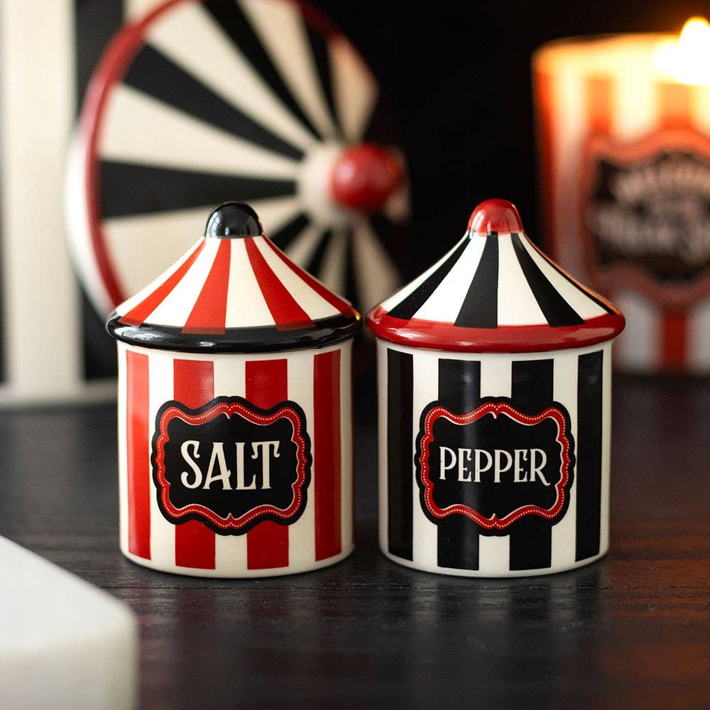 Two circus tent shakers on dark background with carnival items