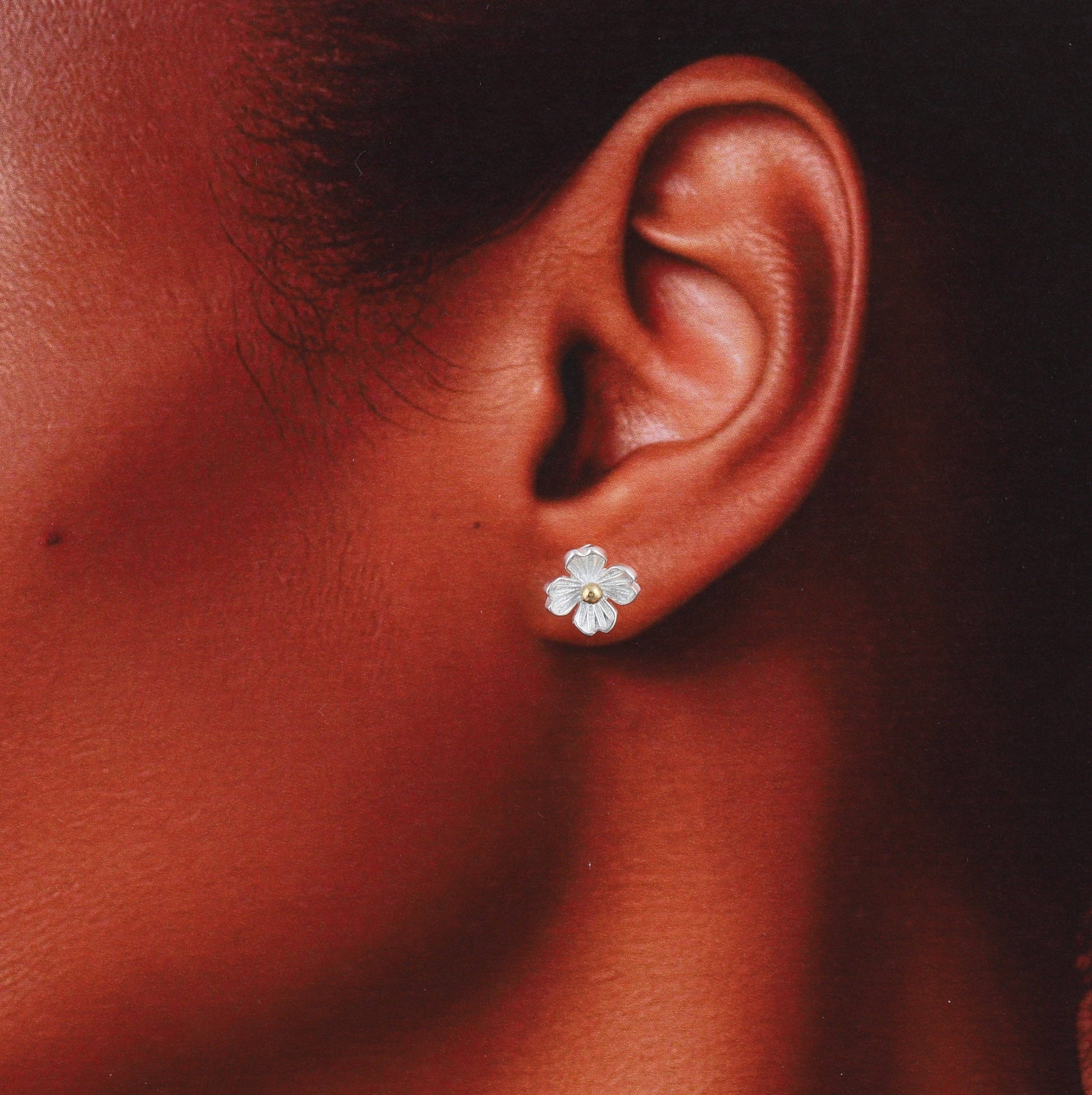 Silver four-petal blossom earrings, close-up detail