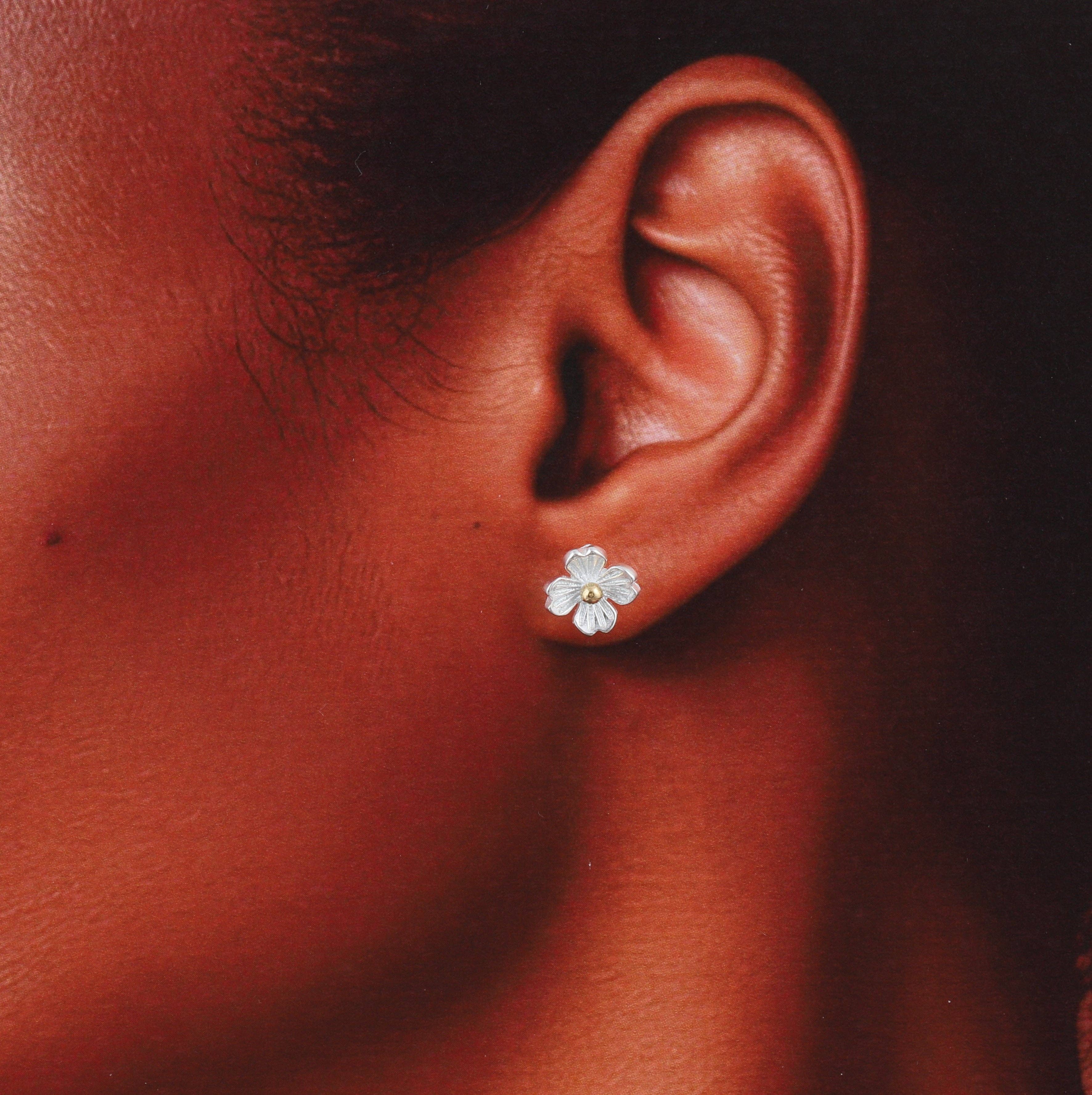 Silver four-petal blossom earrings, close-up detail