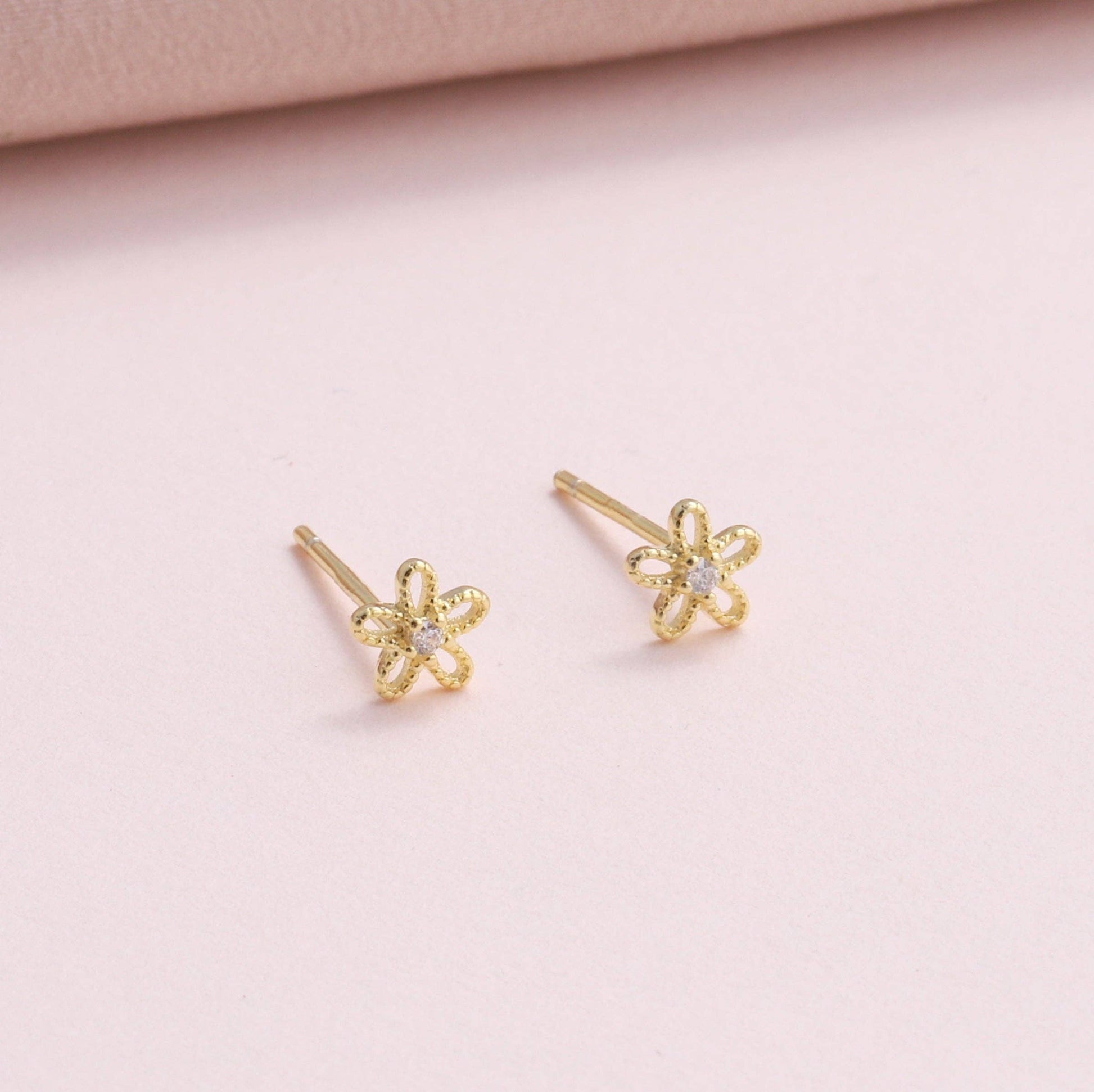 Silver and gold blossom flower earrings, close-up detail
