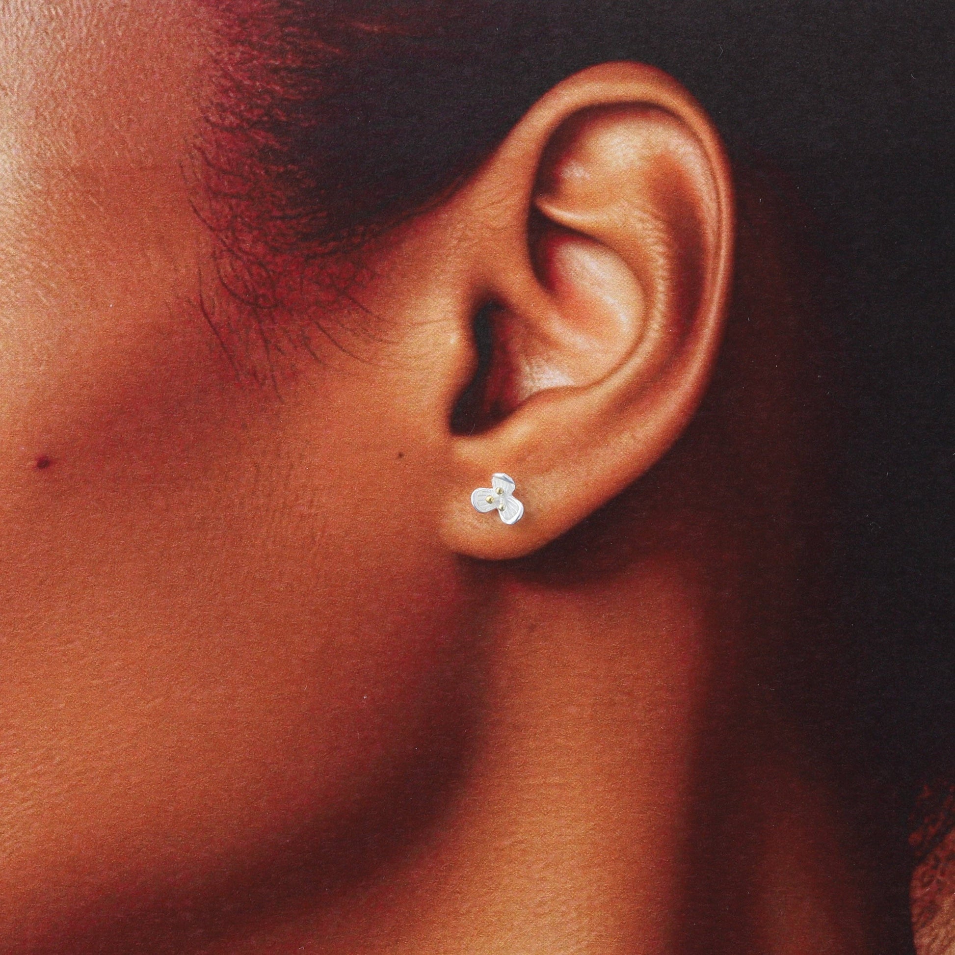 Silver three-petal flower earrings, close-up detail