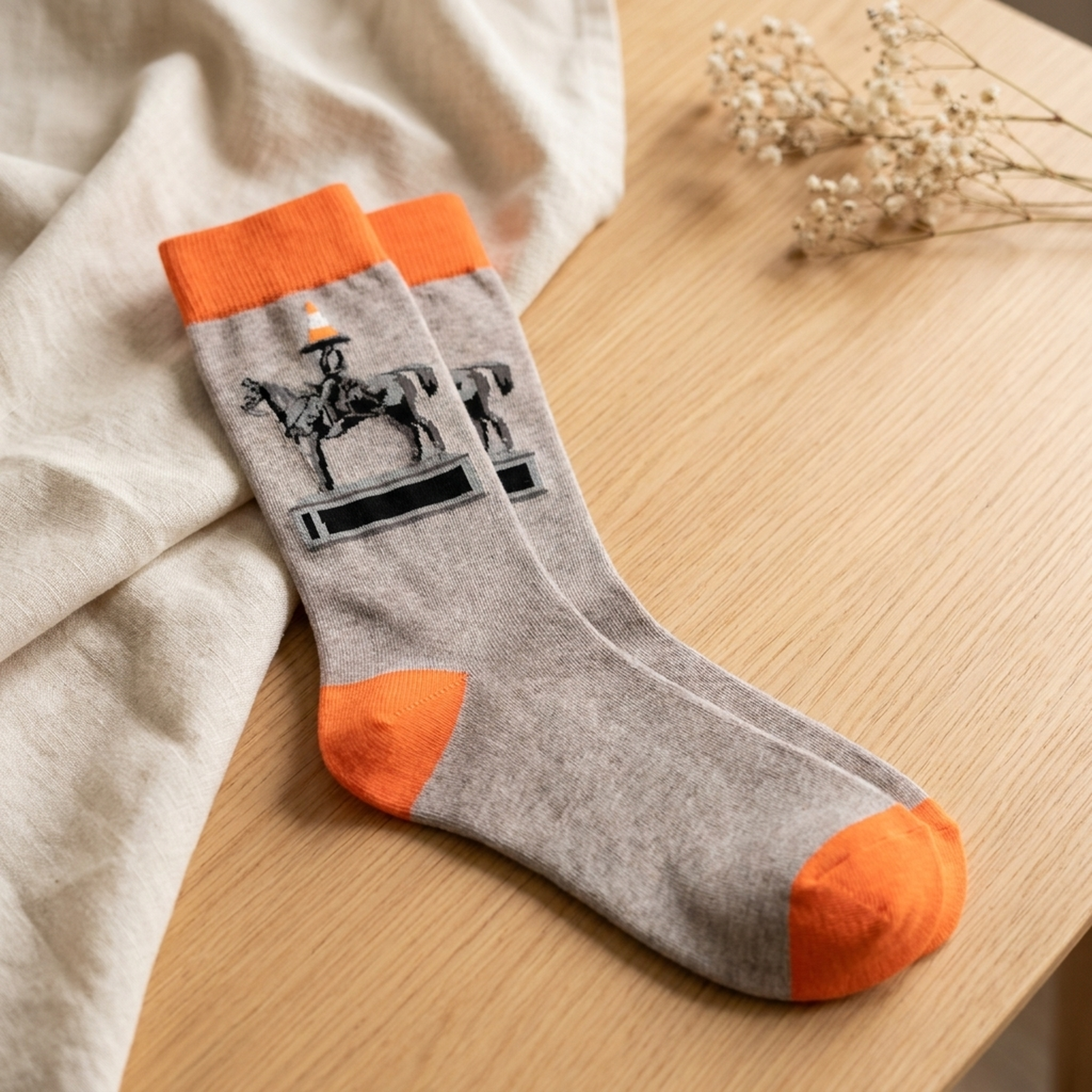 Cone Head socks styled on warm light wood with cream linen and dried flowers