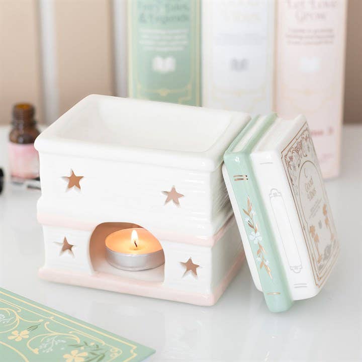 Open book stack oil burner showing lit tea light and star cut-outs