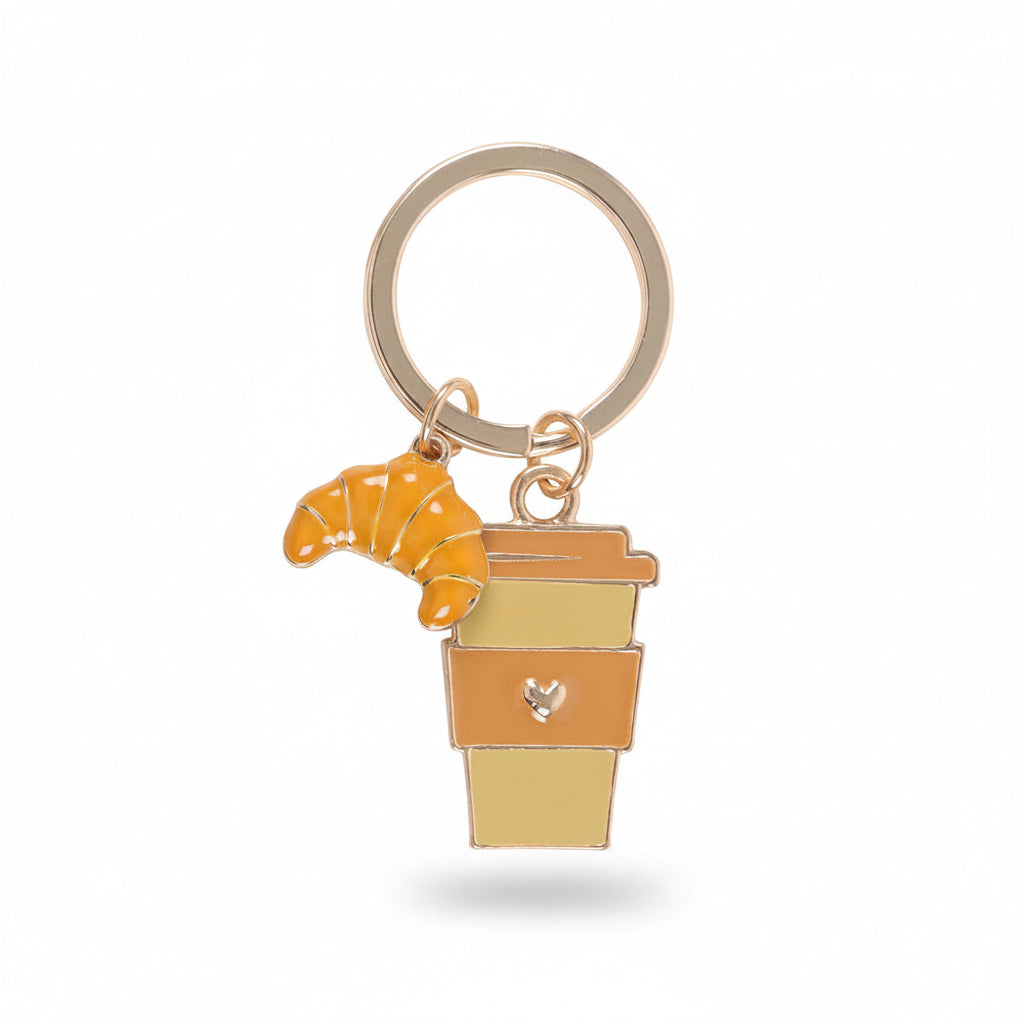 Close-up of enamel coffee cup and croissant charms on gold-toned keyring