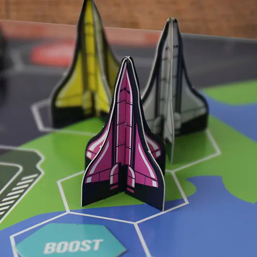 Close-up of colourful spaceship tokens on game board