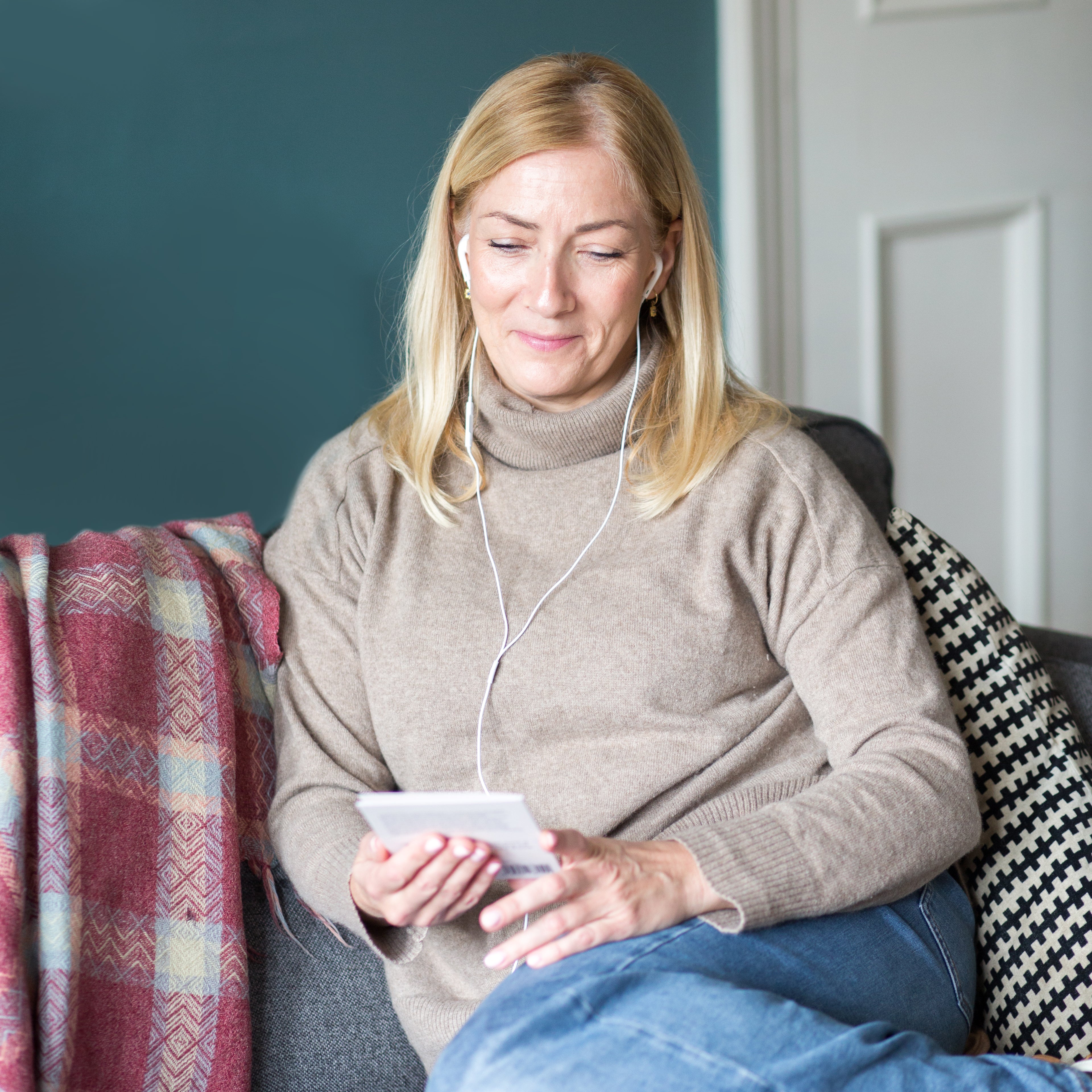 Woman listening to a Spiracle audiobook on headphones after scanning her card