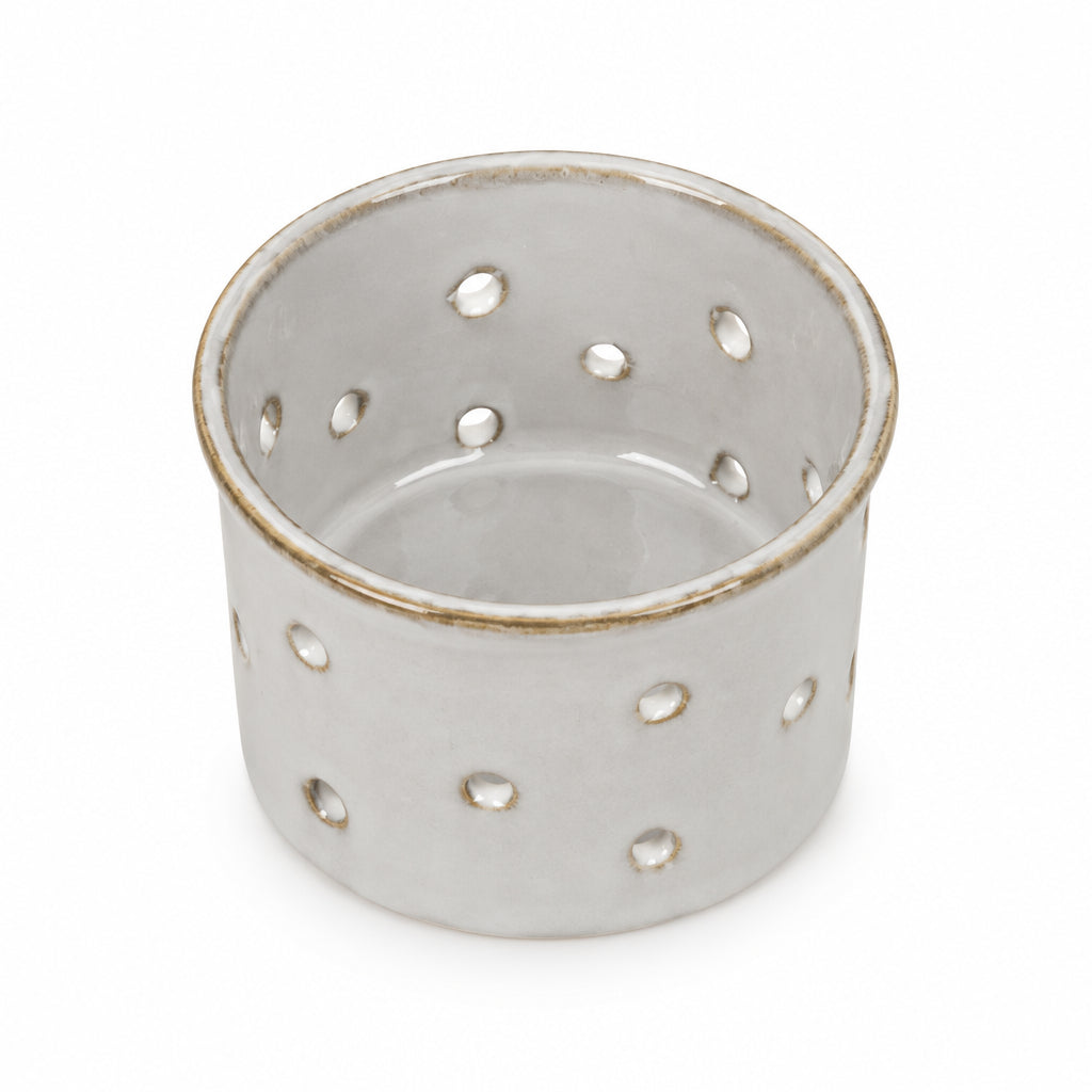 Glazed Ceramic Tealight Holder with pierced dots on a cream background
