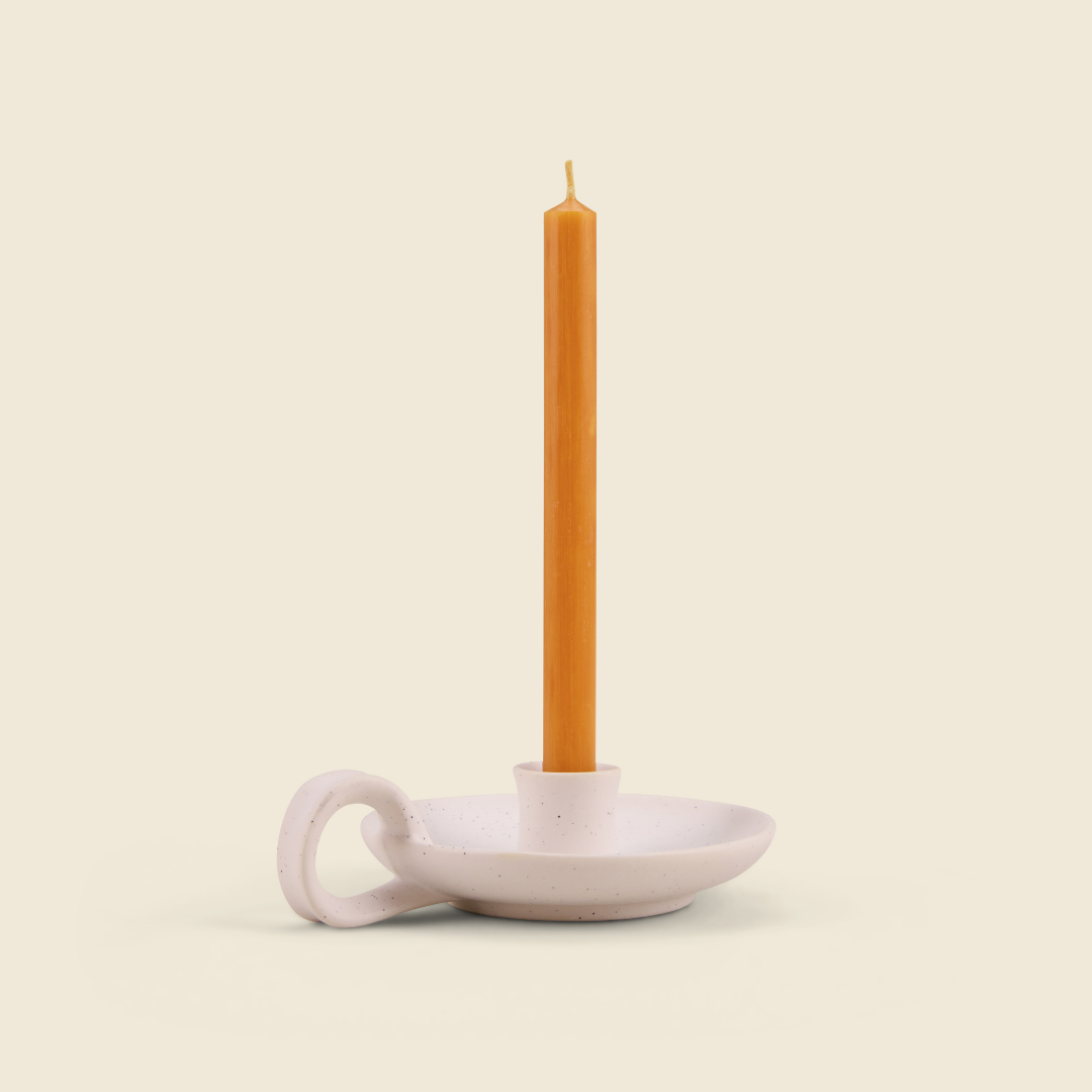 Orange & Cinnamon mini orange candle in a white speckle holder, cream background
