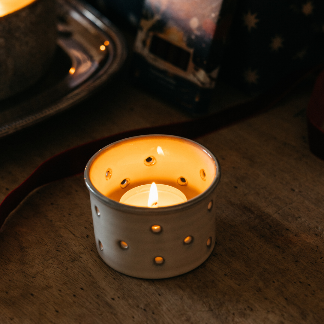 Sacred Forest Christmas tealight lit and glowing in a holder