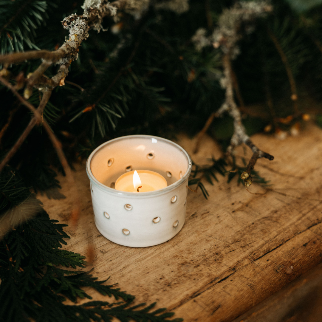 Winter Thyme Christmas tealight lit and glowing in a holder
