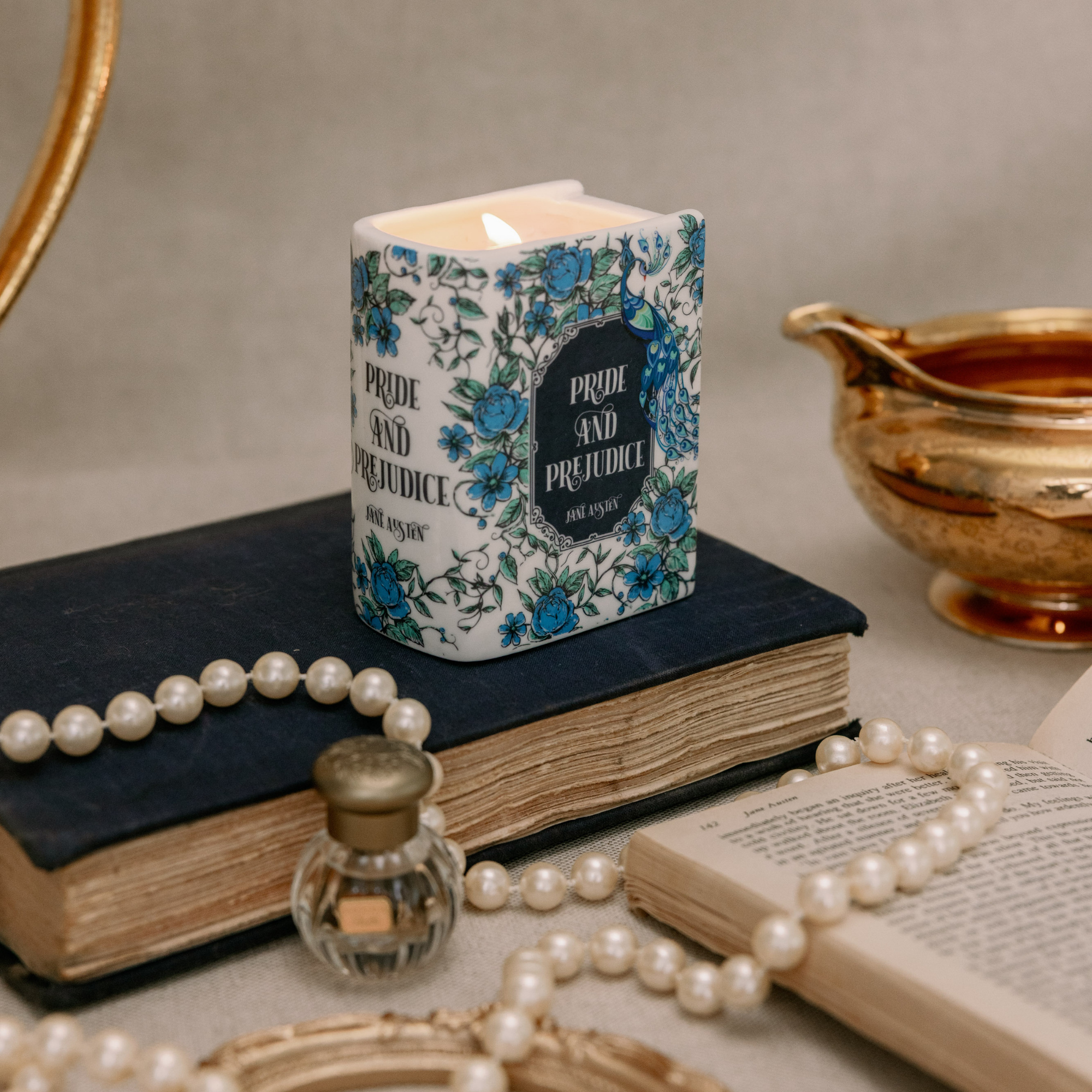 Pride and Prejudice book candle lit in styled setting with pearls and vintage props