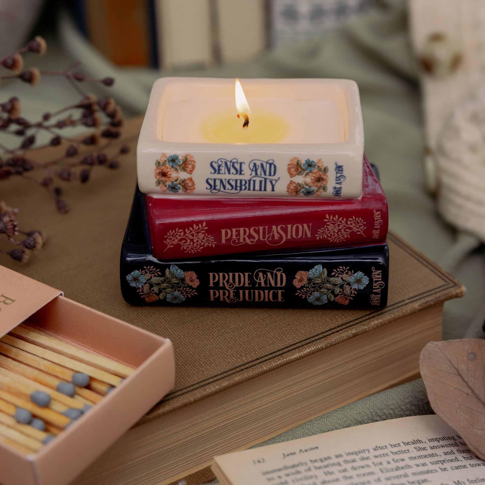 Jane Austen bookstack candle lit and styled with matches and dried flowers