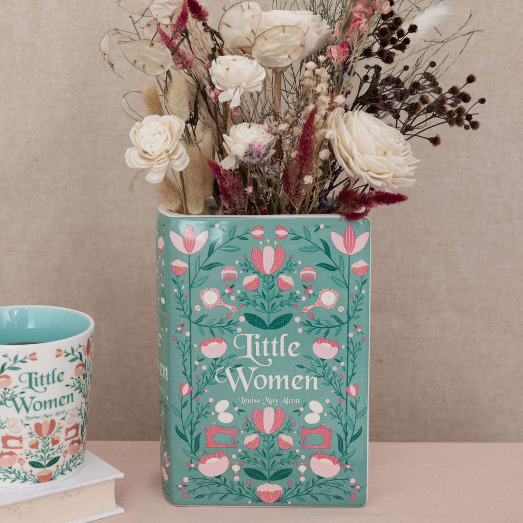 Little Women book vase holding white dried flowers