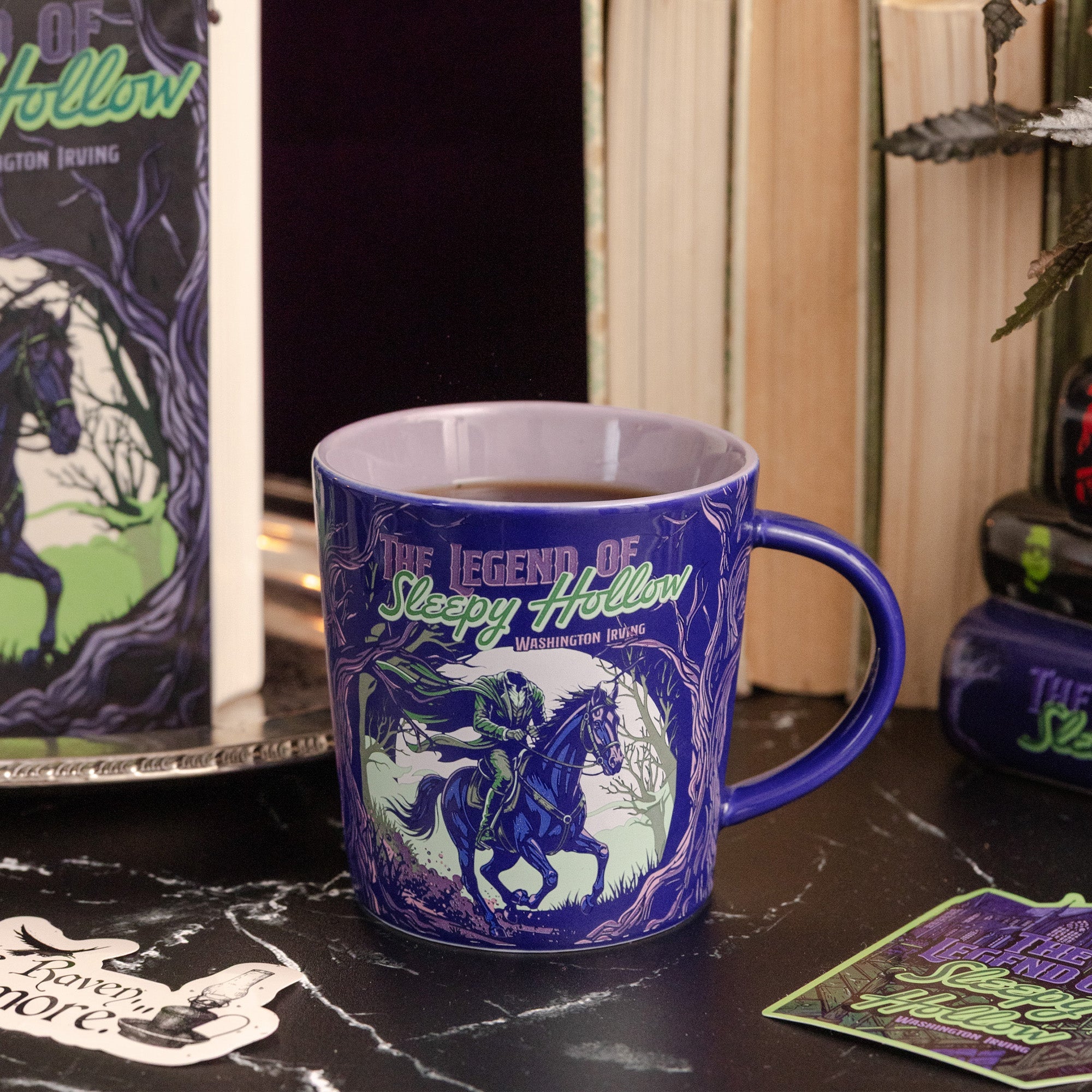 Deep purple Sleepy Hollow mug styled with books on a dark surface