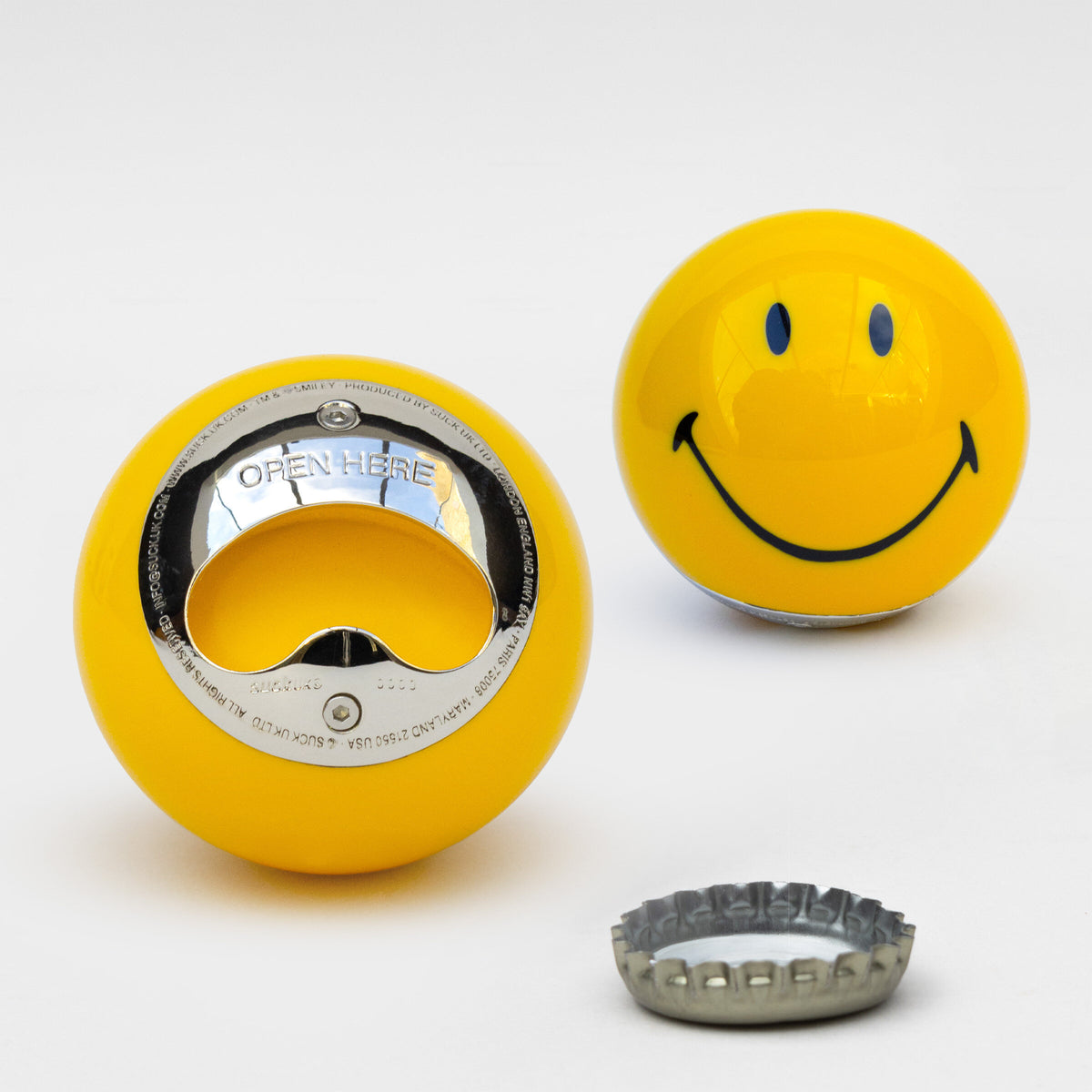 Yellow Smiley bottle opener front and back with a bottle cap, grey background