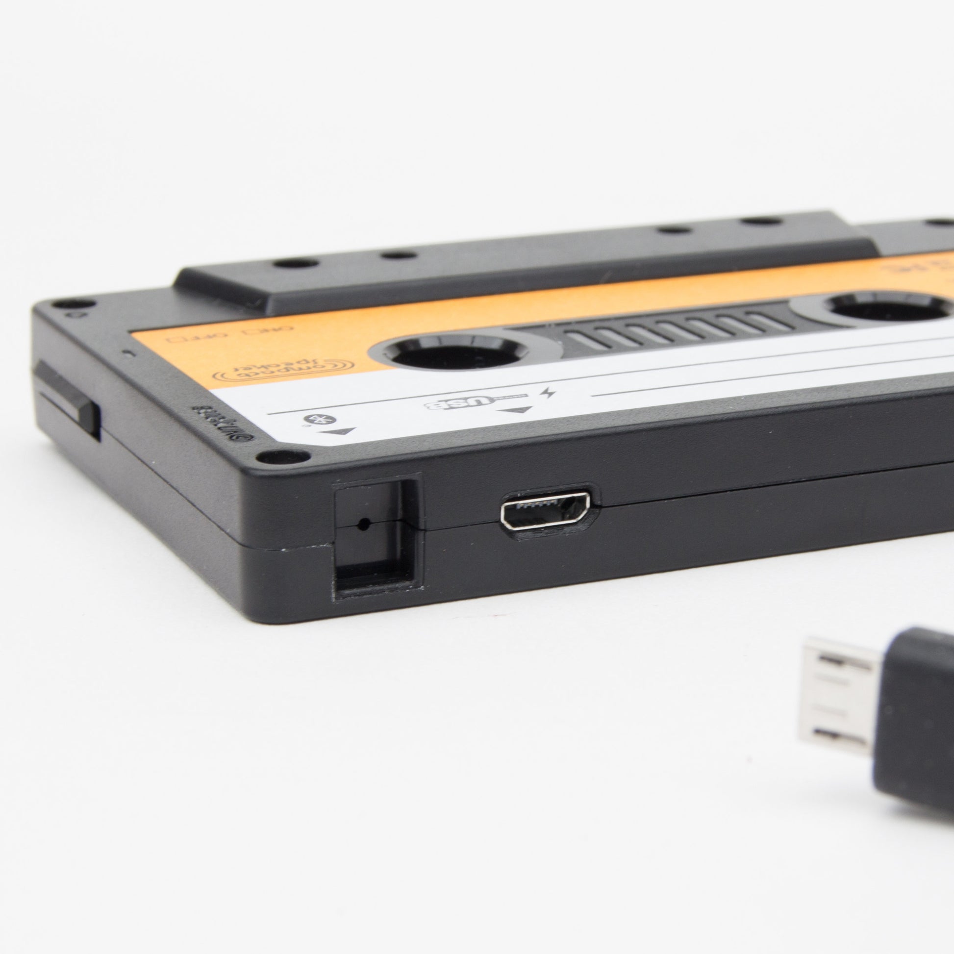 Close-up of cassette speaker showing USB charging port and switch