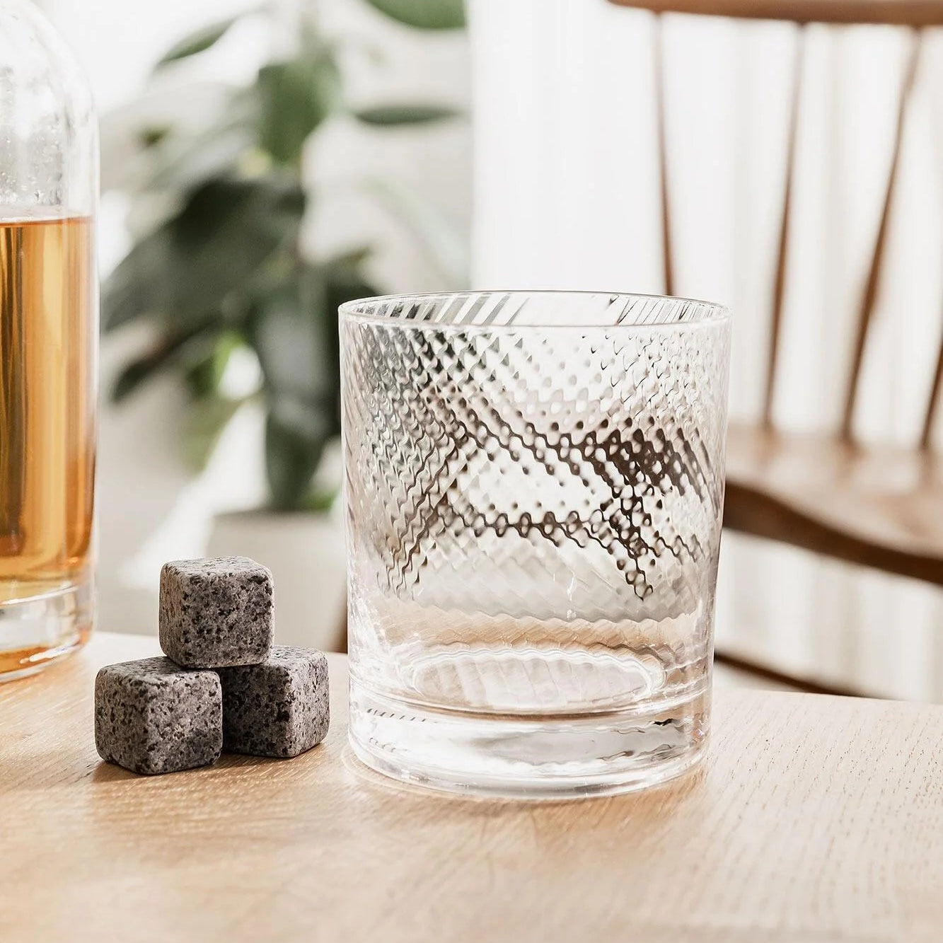 Empty twisted glass with whisky stones on tabletop.