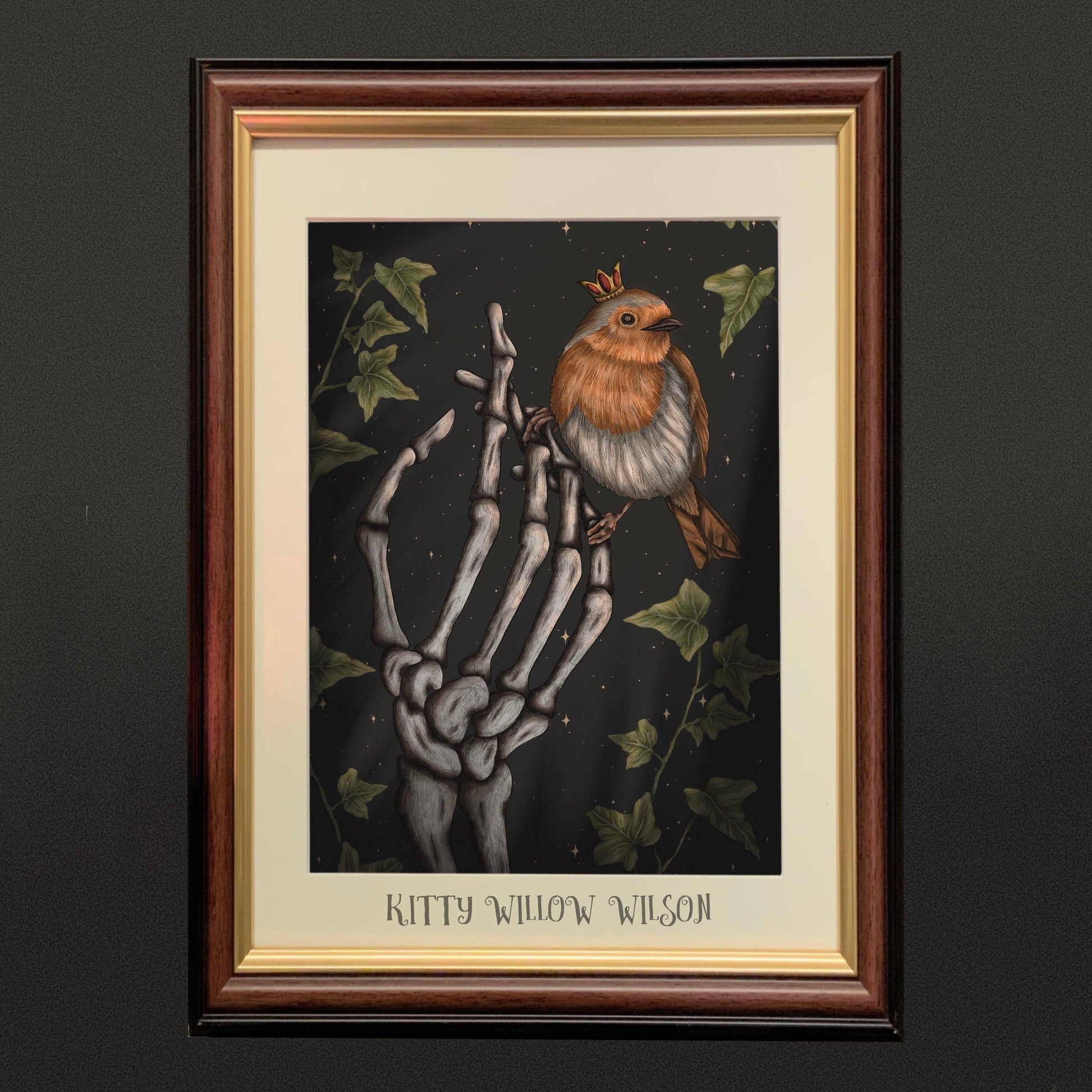 A4 art print of a crowned robin perched on a skeletal hand with ivy, shown framed